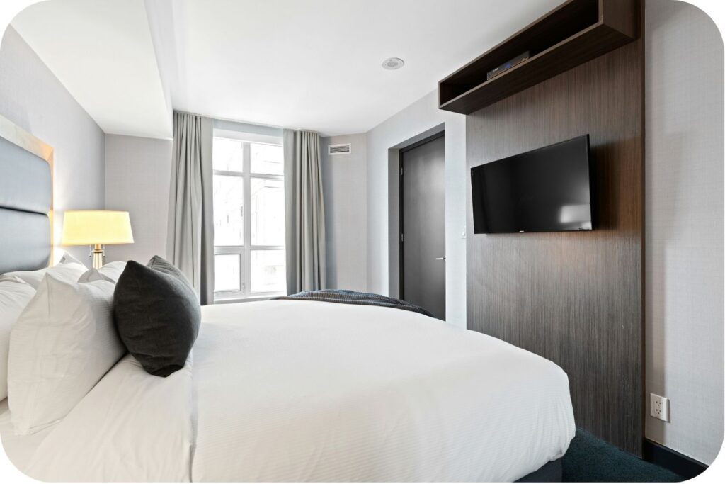 A typical hotel room setup with a bed and TV, showing the limitations of long stays.